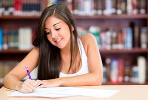 Beautiful young woman studying at the library