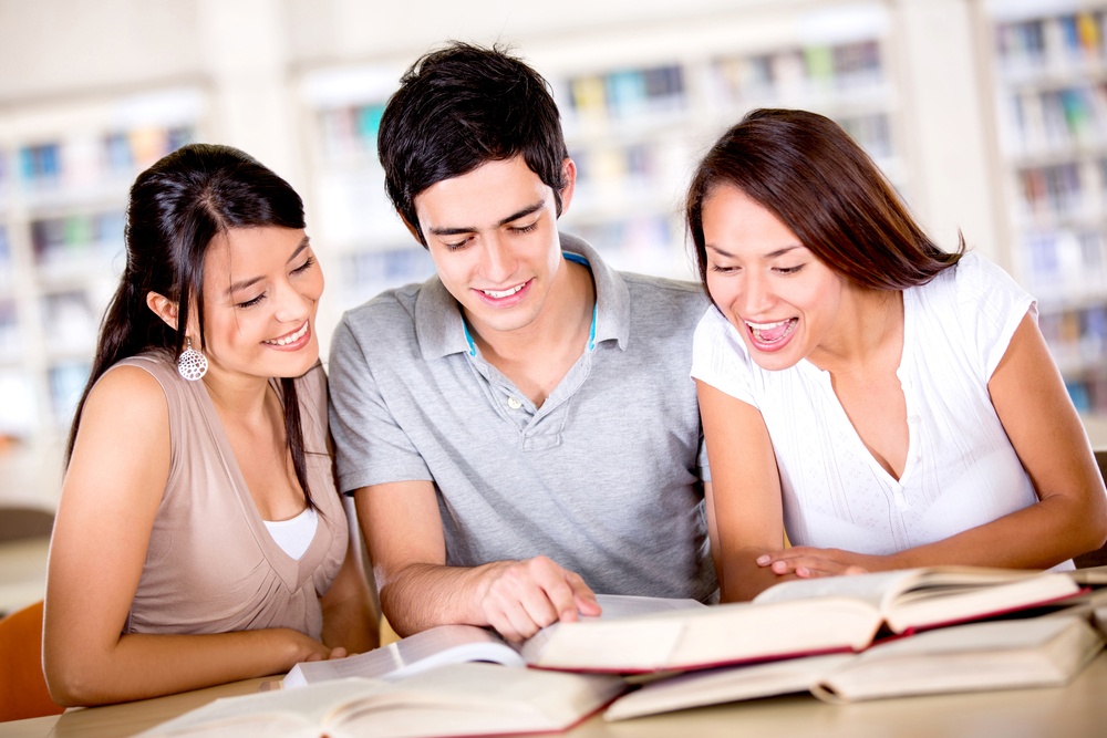 Group of college students studying at the library